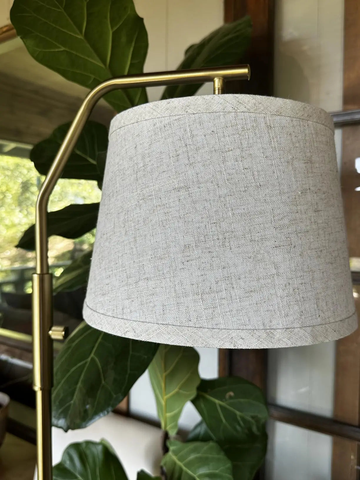 An adjustable-angle arc floor lamp with a metallic finish and a spherical shade, designed to provide flexible and stylish lighting over a dining table or seating area.