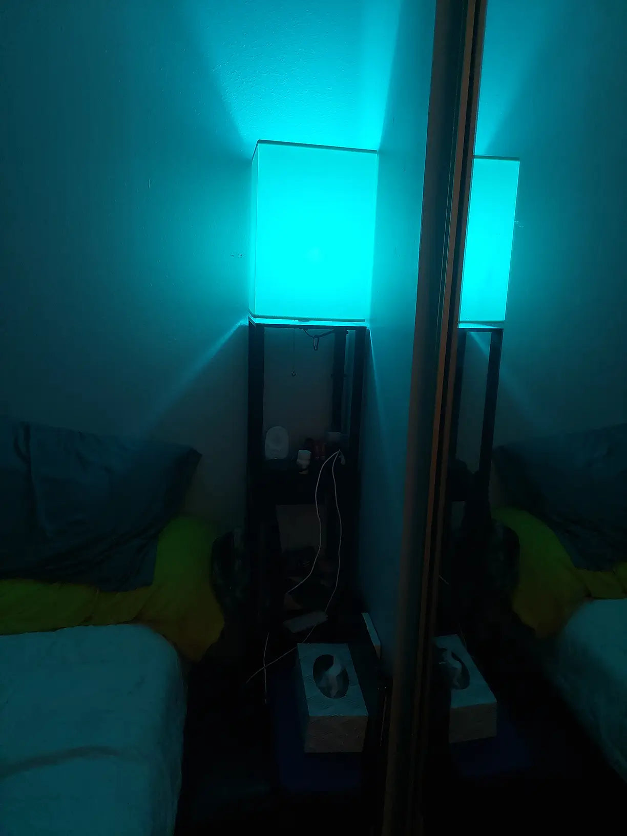 An adjustable RGB corner floor lamp emitting vibrant purple and blue light, controlled by a remote and APP, creating dynamic ambient lighting for a modern living space.