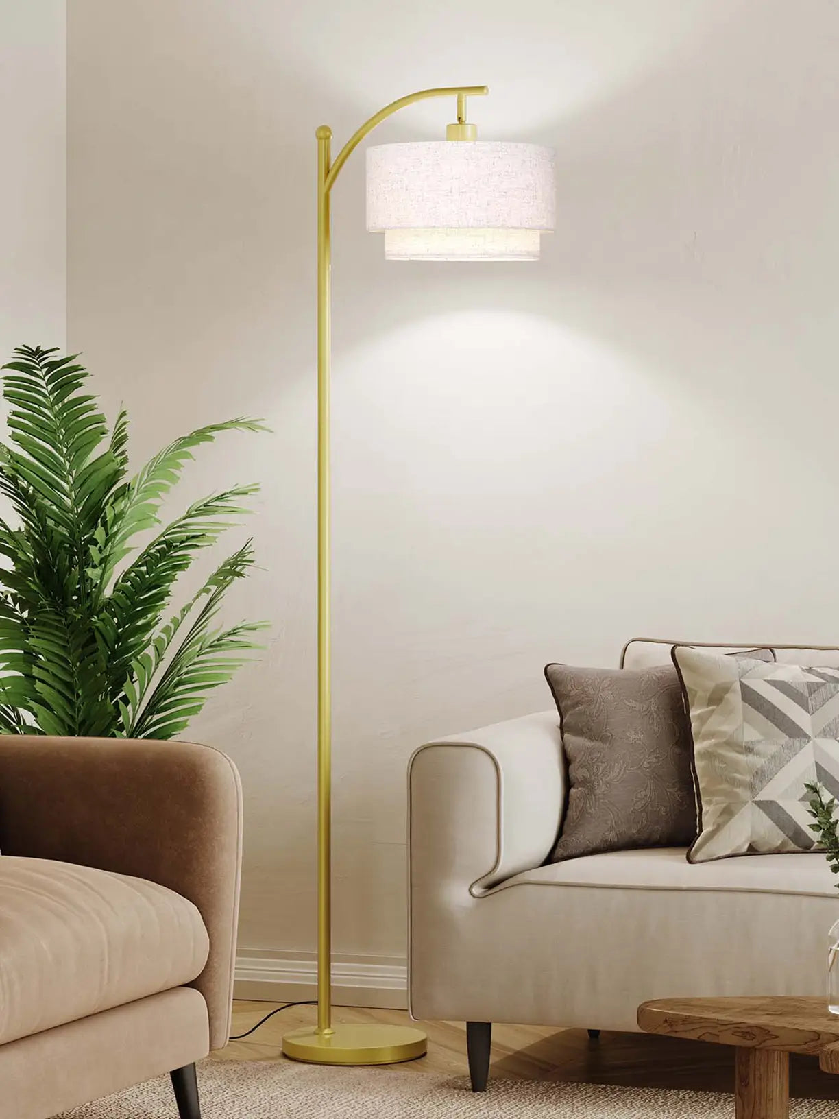 A contemporary gold arc floor lamp with a spherical clear glass shade, providing a stylish and bright light source over a sofa in a modern living space.