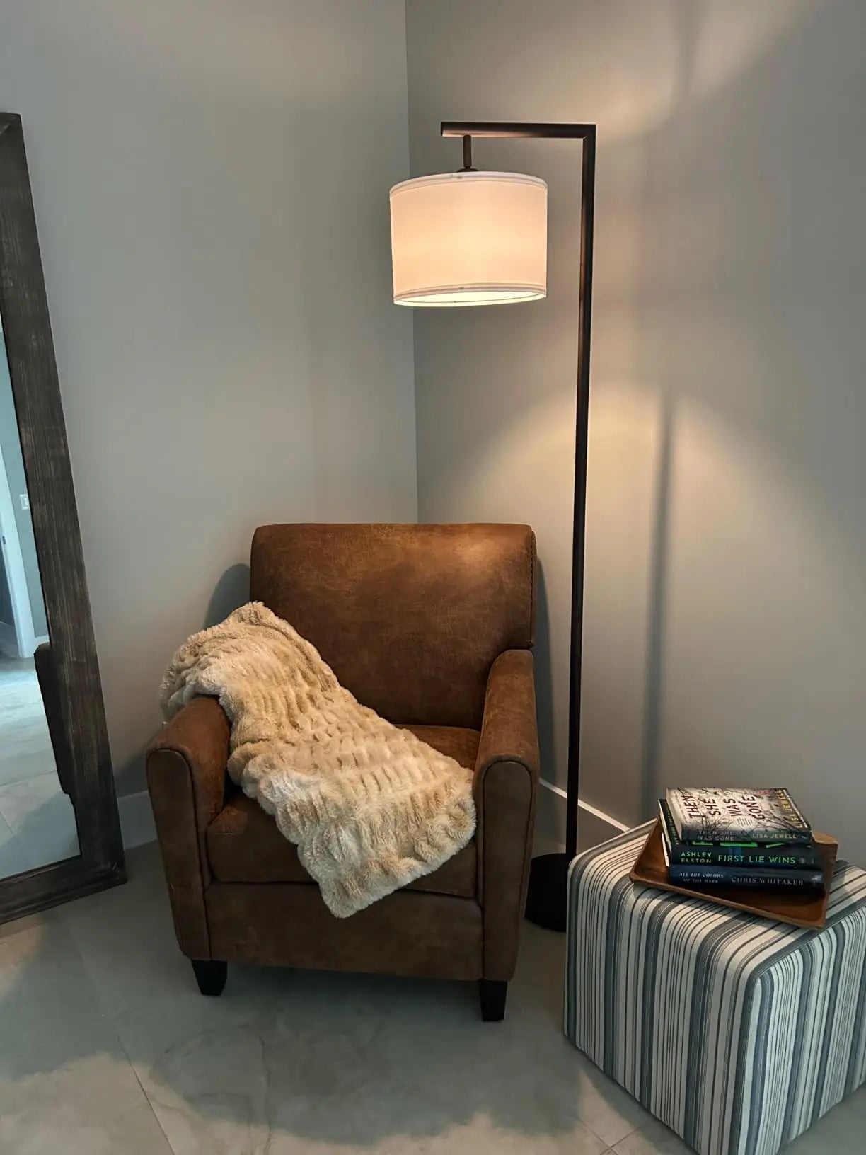 An elegant gold arc floor lamp with a graceful curve and a pristine white fabric shade, bringing a touch of luxury and soft ambient light to a refined living space.