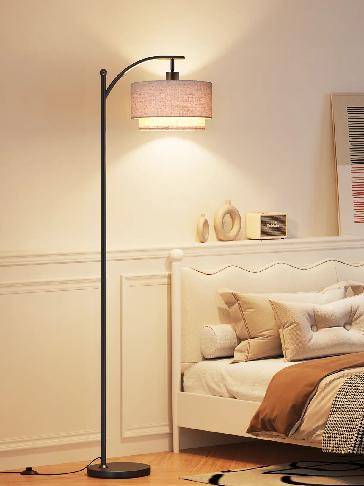 A minimalist arc floor lamp with a white cylindrical shade and a slim, dark metal frame, offering soft ambient light in a modern bedroom setting.