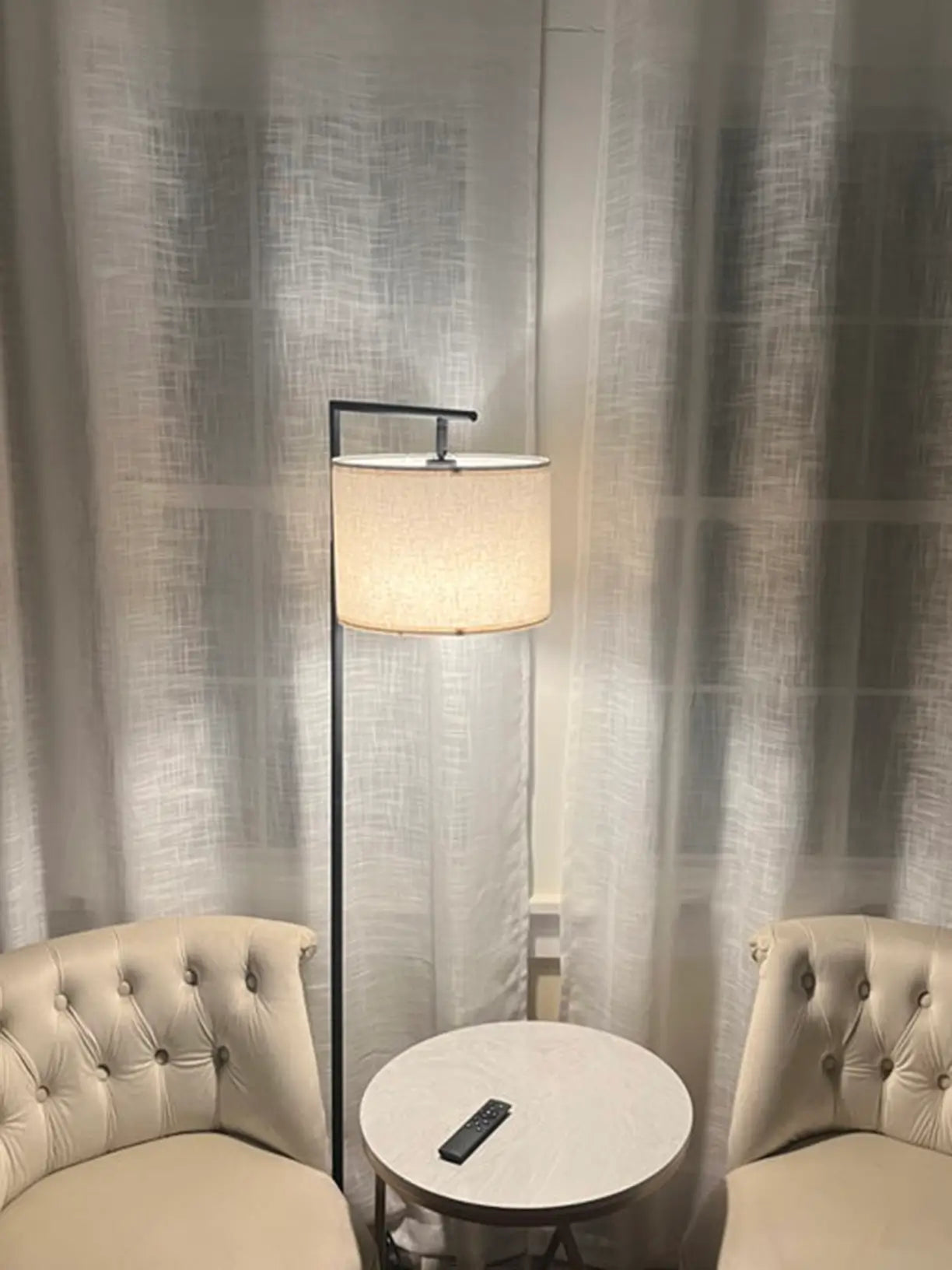 A modern arc floor lamp, drum-shaped shade, providing elegant overhead lighting for a spacious living room.