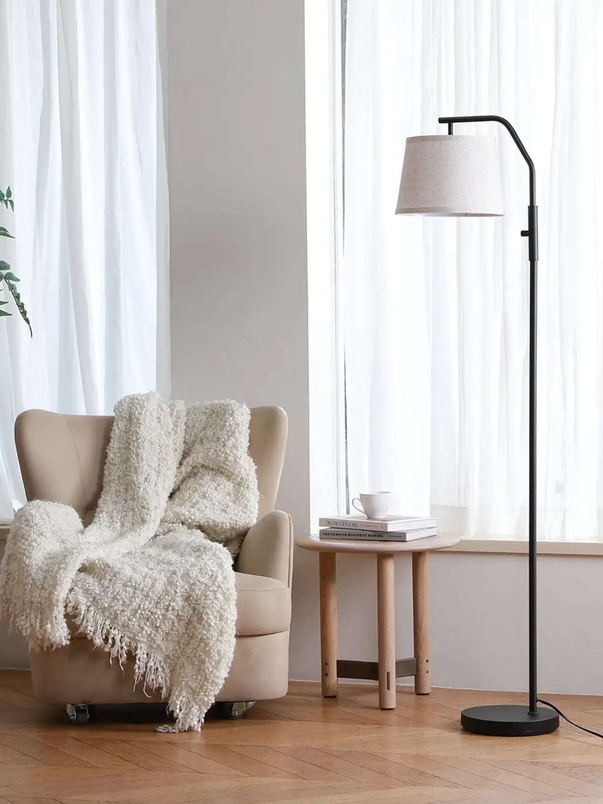 A modern brass arc floor lamp featuring a gracefully curved arm and a contrasting white dome shade, offering elegant overhead lighting for a stylish seating area.