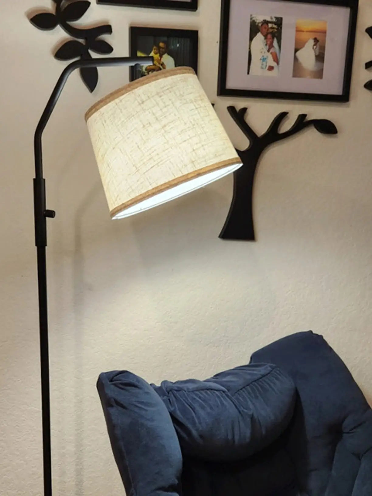A sleek black arc floor lamp with a classic domed shade and a sturdy base, extending over a sofa to provide a chic and functional lighting solution in a living room.