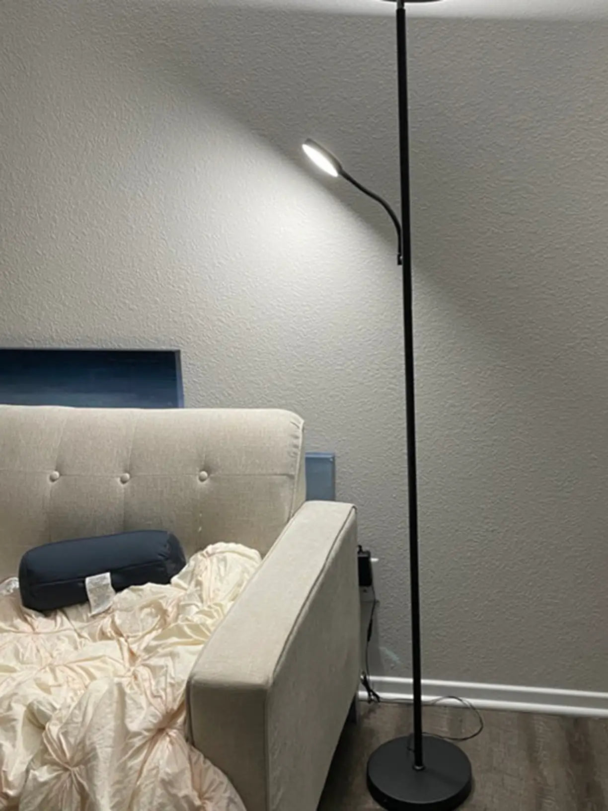 A sleek metal torchiere floor lamp providing general room illumination, complemented by an attached adjustable reading lamp with a sub LED light, perfect for a cozy reading nook.