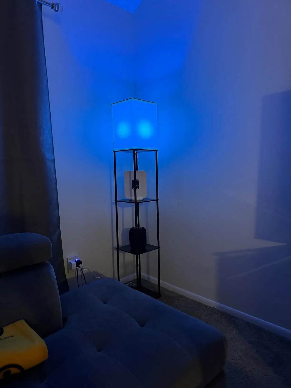 A smart corner RGB floor lamp glowing with a warm orange light, offering seamless control through an app or remote to set the perfect mood lighting in a bedroom or living space.