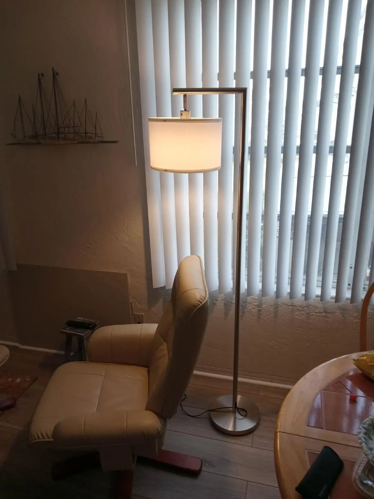 A stylish arc floor lamp with a metallic finish and a clean, modern design, extending over a sectional sofa to provide ideal lighting for reading or conversation.