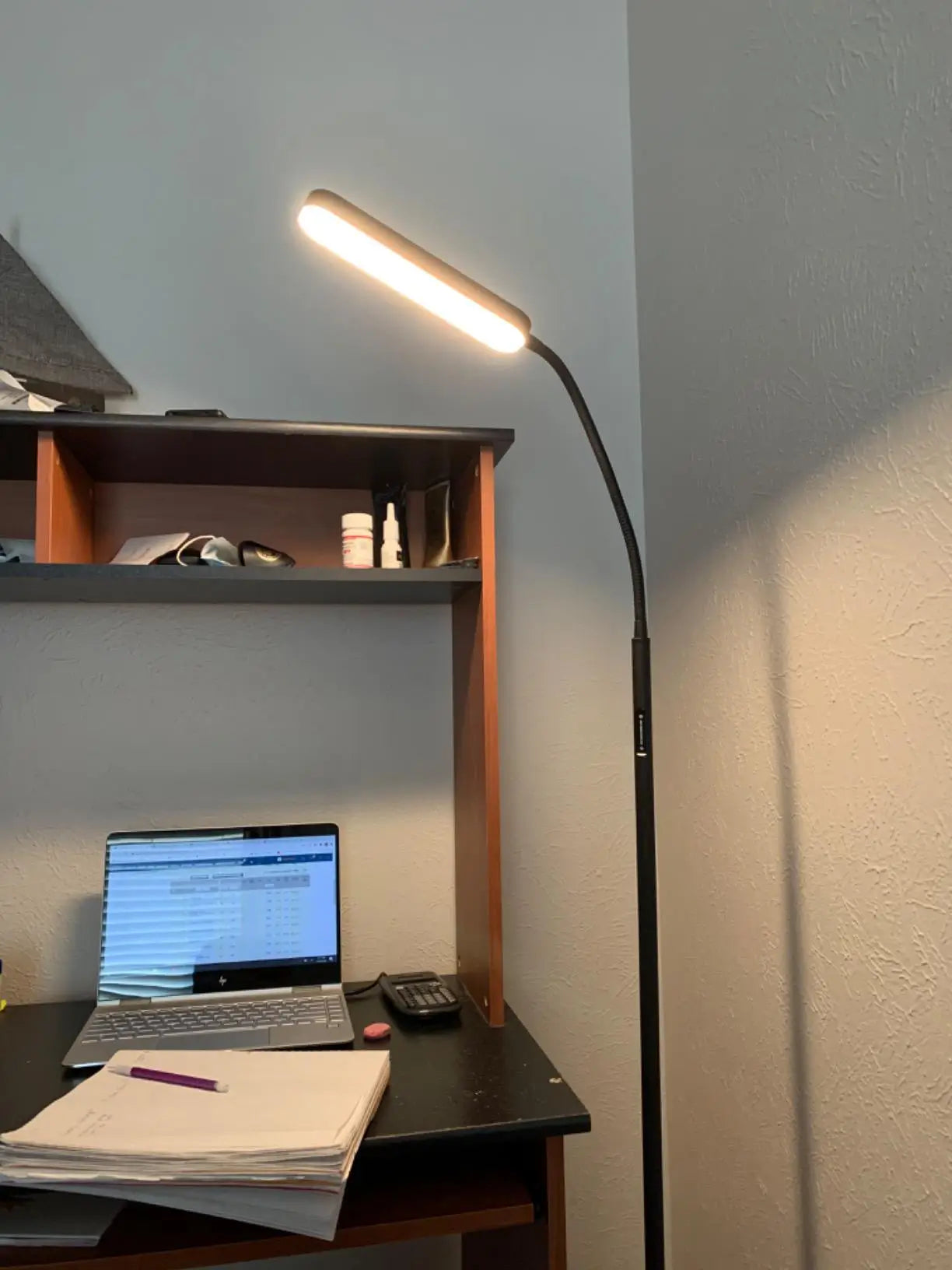 A tall LED reading floor lamp with a simple, functional design, providing direct light ideal for a bedroom, study, or any area requiring focused illumination.