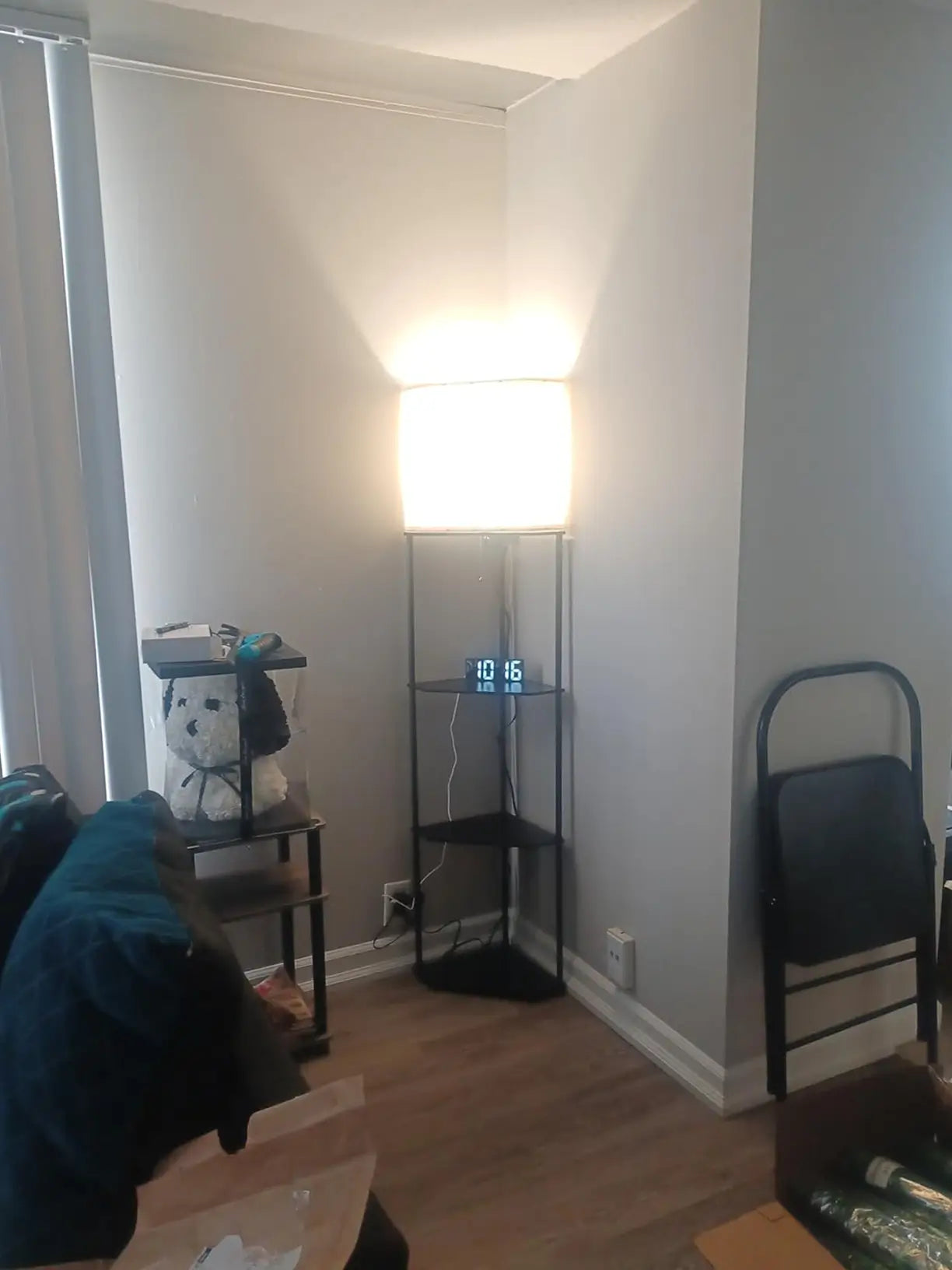 A space-saving white corner shelf floor lamp with a minimalist design, perfect for small apartments or dorm rooms, offering both lighting and display shelves.