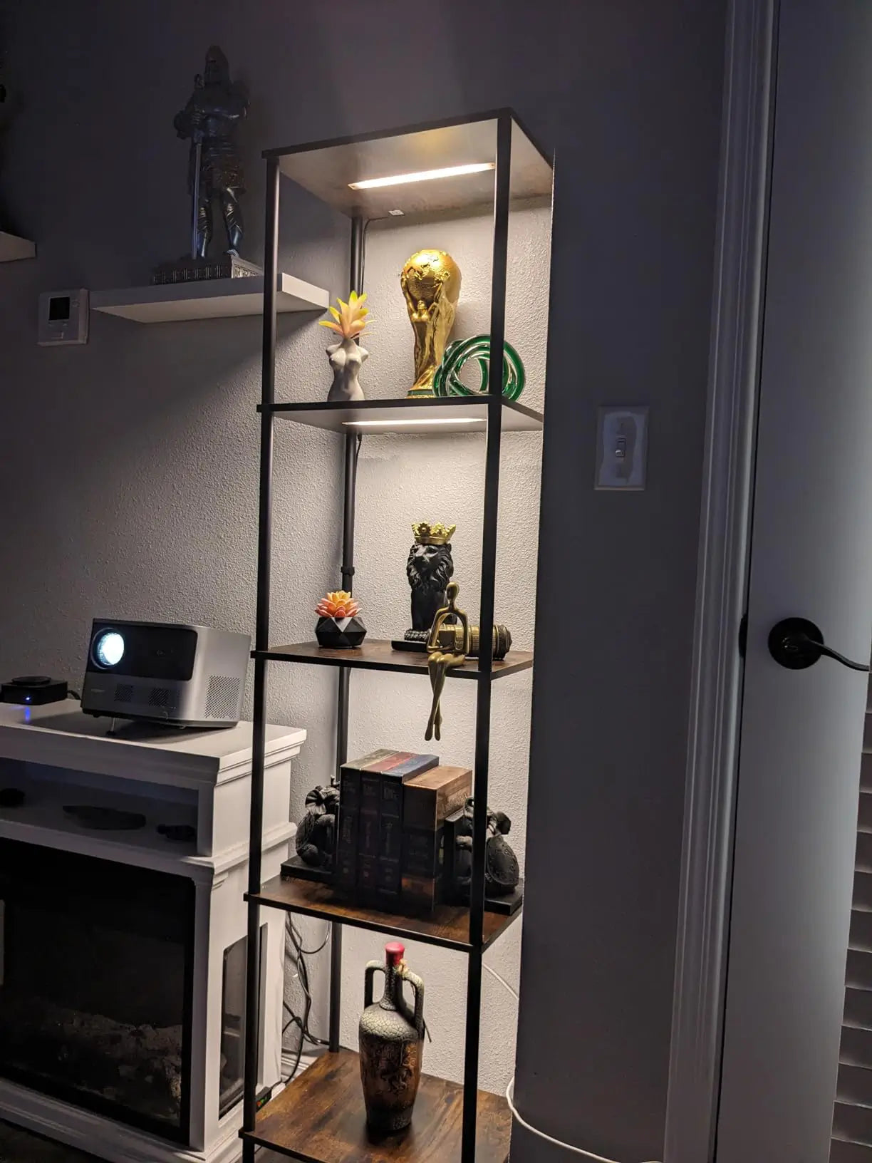 A wooden display shelf featuring warm-toned adjustable lights that highlight decorative elements and books, creating a cozy and inviting atmosphere in a living room.