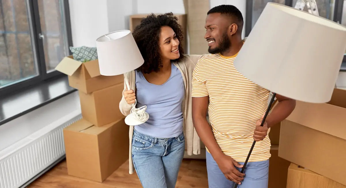 couple is packing the floor lamp into a cardboard box