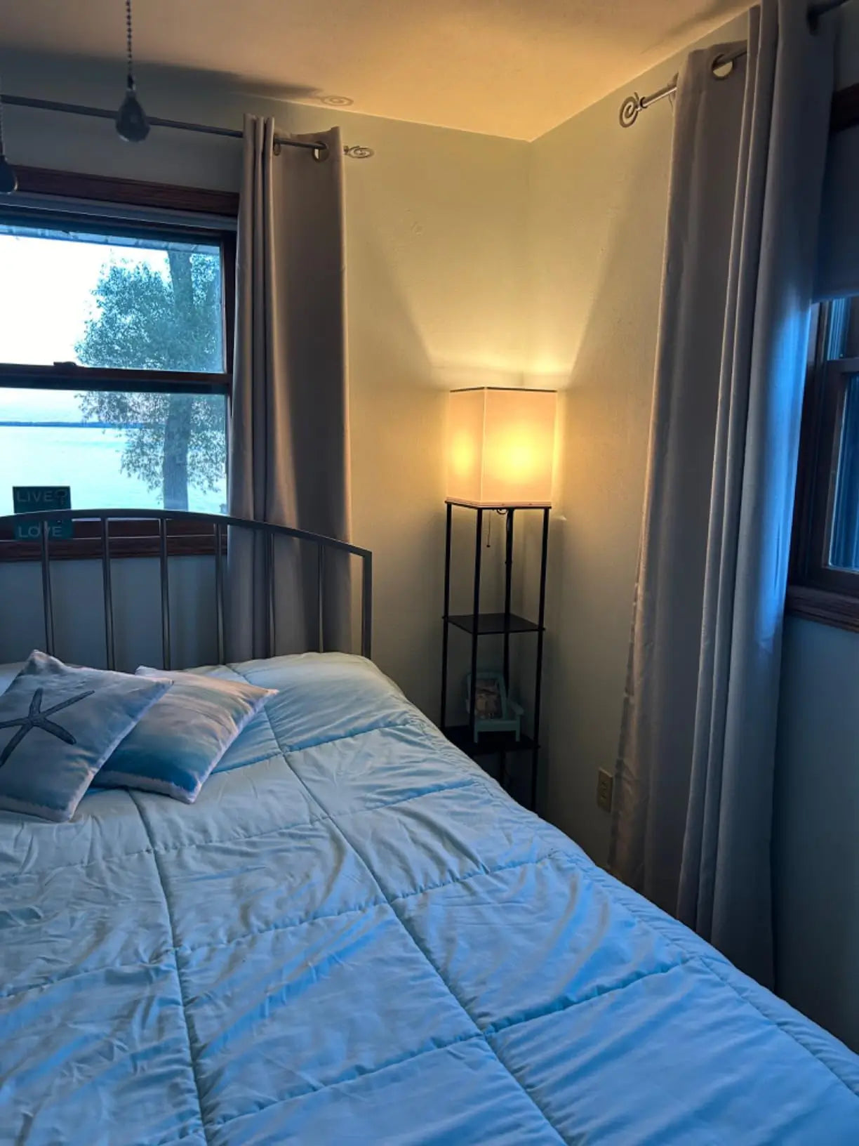 A sleek, minimalist black floor lamp designed open storage space shelf. This modern floor lamp provides subtle ambient light while offering a convenient spot for keys or a small decorative item in an entryway or living area